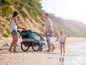 Eine Familie mit einem Qeridoo Kinderwagen am Strand.