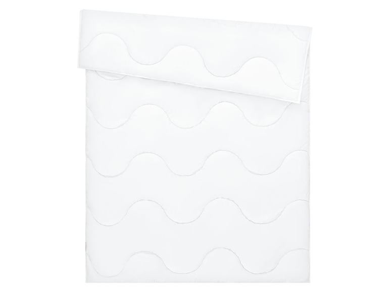 Weißes Bettzeug mit Wellen-Steppung.