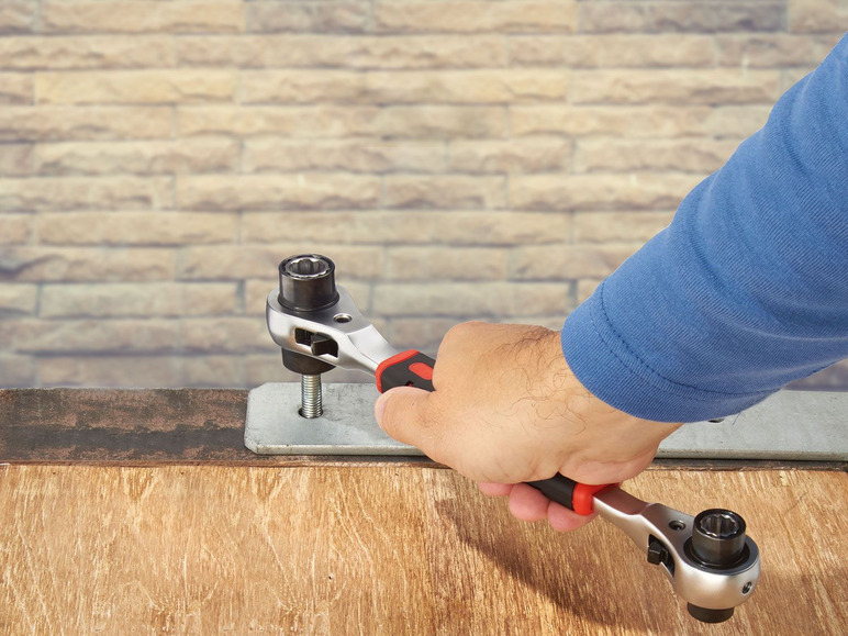 Eine Hand verwendet eine Ratsche mit einer Nuss, um eine Schraube festzuziehen.