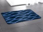 Eine Badematte mit einem geometrischen Muster in Blau und Dunkelblau.