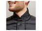 Ein Mann trägt eine schwarze Steppjacke.