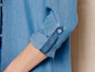 Eine blaue Jeansbluse mit hochgekrempelten Ärmeln.