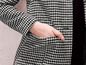 Eine schwarz-weiße karierte Jacke mit einer Tasche.