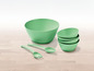 Eine große grüne Schüssel, vier kleinere Schüsseln, ein Servierlöffel und eine -gabel.