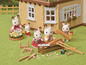 Sylvanian Families Kaninchen bauen Möbel vor einem Haus.