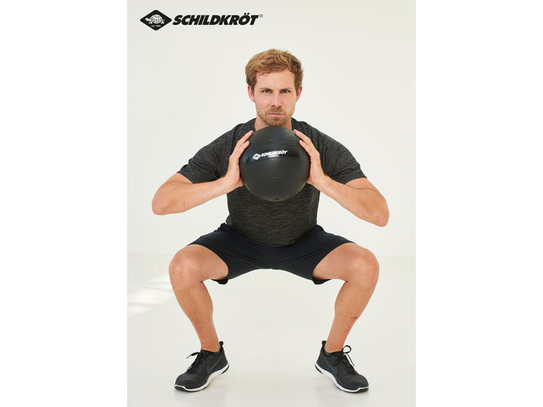 Mann macht Kniebeugen mit einer schwarzen Medizinball von Schildkröt.
