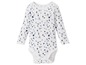Ein weißer Babybody mit langen Ärmeln und Sternenmuster.