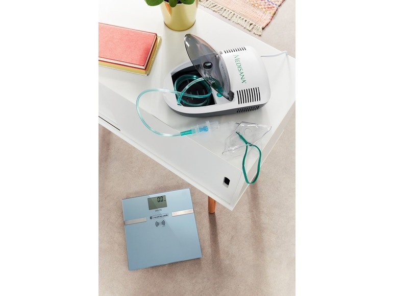 Ein Medisana Vernebler und eine Health o meter Waage auf einem weißen Tisch.