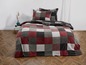 Eine rot-graue Plaid mit Karomuster auf einem Bett.