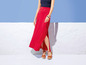 Eine Frau trägt einen roten Maxirock mit Schlitz.