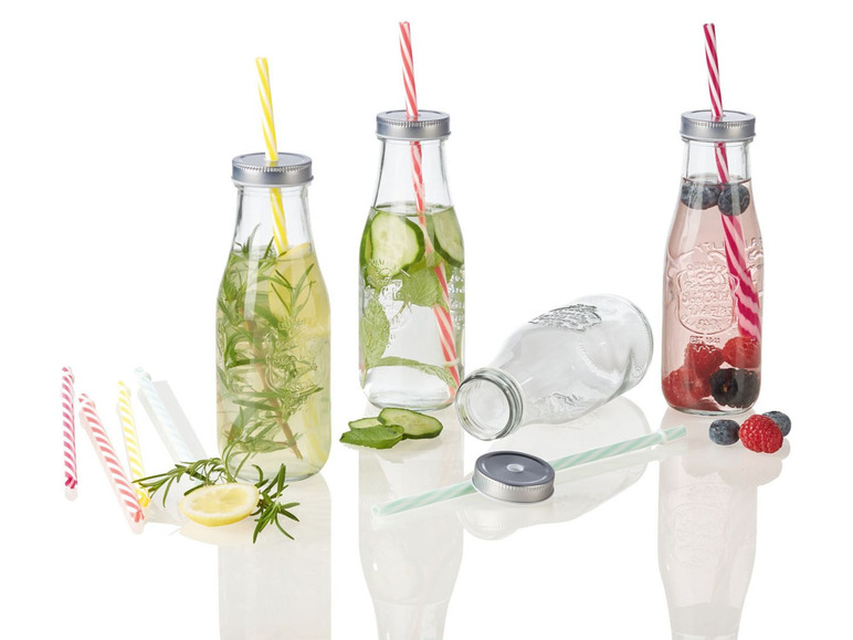 Glasflaschen mit verschiedenen Getränken, wie Zitronenwasser, Gurkenwasser und Beerengetränken.