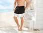 Mann trägt schwarze und weiße Badehosen am Strand.