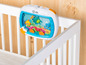 Baby Einstein Nachtlicht mit Meeresmotiv an einem Babybett befestigt.
