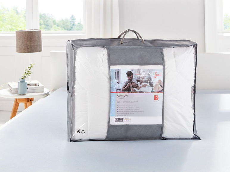 Trendline Comfort Steppdecke in einer grauen Aufbewahrungstasche.