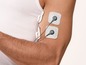 Mann mit Elektroden am Arm zur Muskelstimulation.