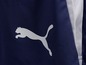 Ein dunkelblaues Kleidungsstück mit einem weißen Puma-Logo.