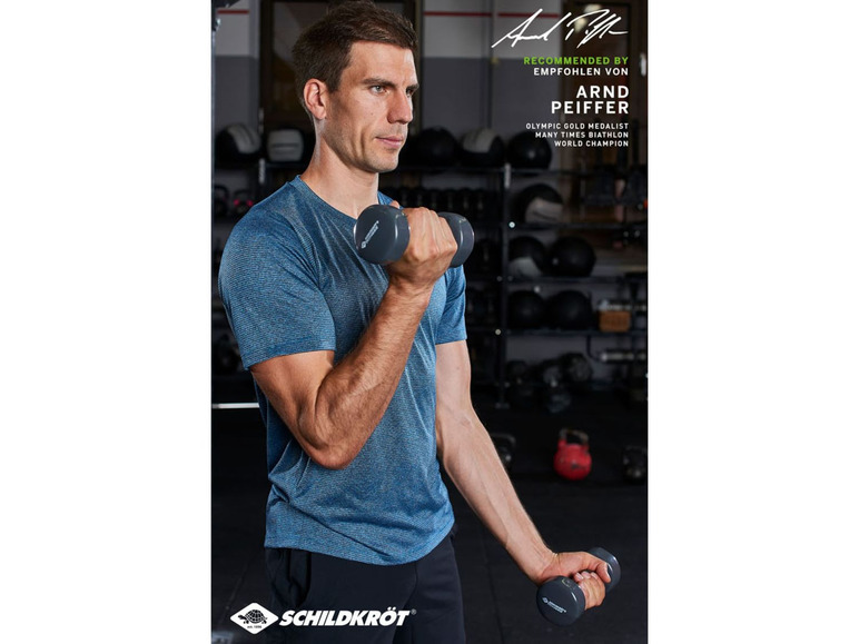 Mann in einem T-Shirt, der Schildkröt-Hanteln hebt.