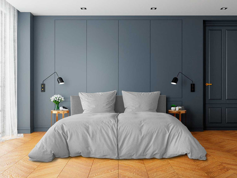 Ein grauer Bettbezug auf einem Bett in einem modernen Schlafzimmer.