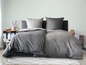 Ein grauer Bettbezug auf einem Bett mit passenden Kissen.