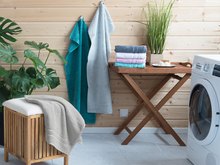 Badezimmer mit Handtüchern, Bosch-Trockner und Pflanzen.