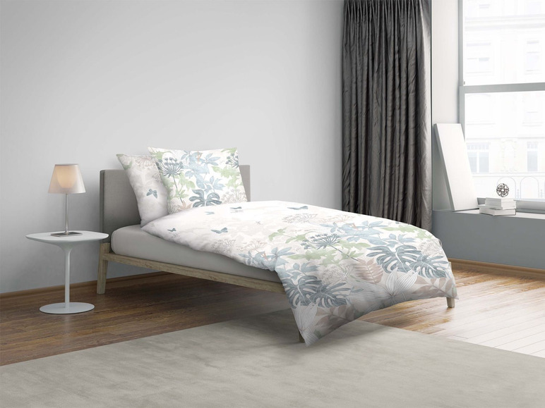 Ein Bett mit Bettwäsche mit Blumenmuster.