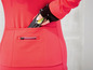 Eine rote Fahrradjacke mit einer Tasche für einen Energieriegel.