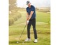 Ein Golfer in einem blauen Polo-Shirt und schwarzen Hosen mit einem Golfschläger auf einem Golfplatz.