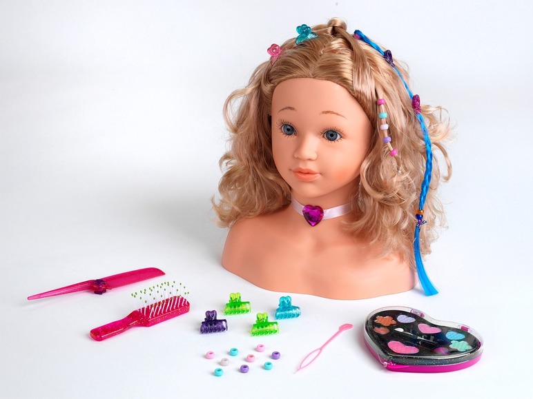 Ein Puppenkopf mit blonden Haaren, Haarschmuck und einem Make-up-Set.