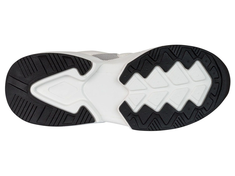 Weiße Sneaker mit schwarzer Sohle.