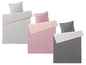 Drei Bettbezüge in gestreiftem Grau, Rosa und Grau.