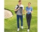 Zwei Golfer in Poloshirts und Golfhosen gehen auf einem Golfplatz.