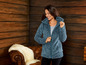 Eine Frau trägt eine blaue Fleecejacke mit Kapuze.