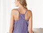 Eine Frau trägt ein lilafarbenes Tanktop aus Baumwolle.