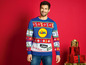 Mann mit einem Lidl Weihnachtspullover und Weihnachtsgeschenken.