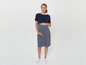 Eine schwangere Frau in einem blau-weiß gestreiften Kleid.