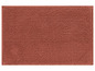 Eine terracottafarbene Badmatte mit weicher, kugeliger Textur.