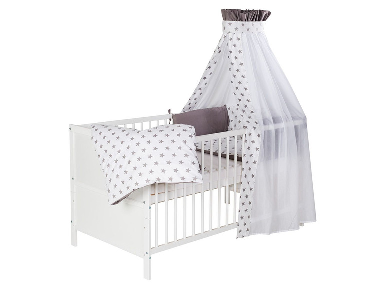 Ein weißes Babybett mit Himmel und Sternen-Bettwäsche.