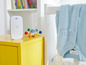 Ein Babyphone von Philips Avent, ein Baby-Overall und Spielzeug in einem Babyzimmer.