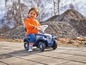 Ein Kind fährt ein blaues Bobby Car