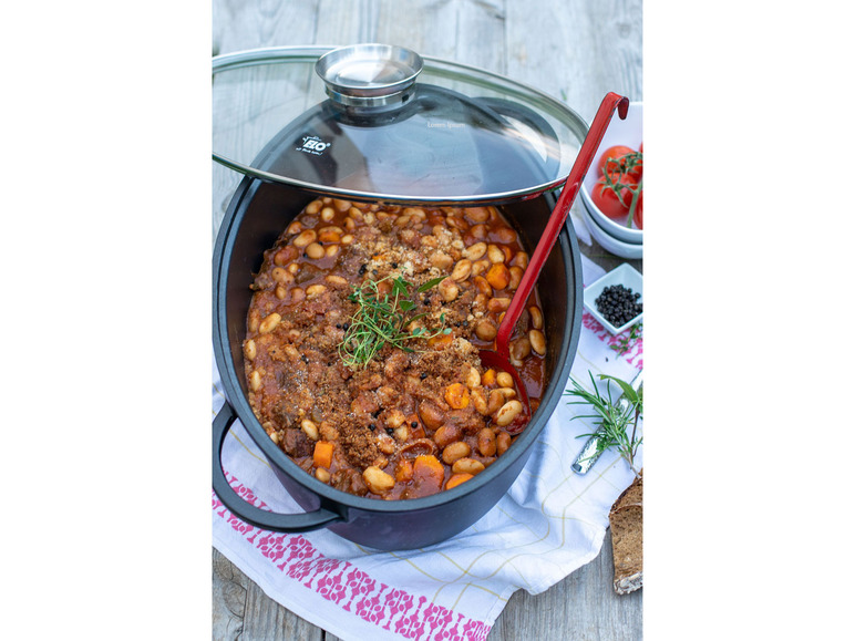 Ein schwarzer Gusseisentopf mit weißen Bohnen und Eintopf.