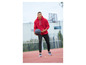 Ein Mann in einem roten Nike Hoodie und schwarzen Hosen dribbelt mit einem Basketball.