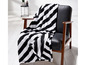 Eine schwarz-weiße gestreifte Decke auf einem Stuhl.