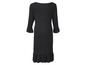 Schwarzes Kleid mit Rüschen an den Ärmeln und am Saum.