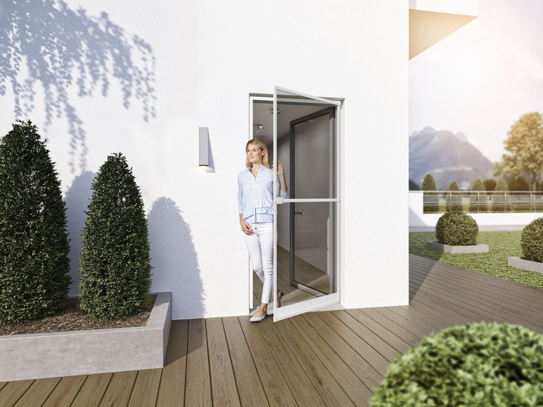 Eine Frau steht vor einer weißen Schiebetür mit Fliegengitter.