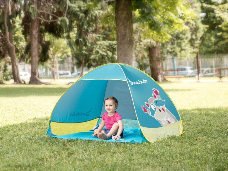 Ein Kind in einem blauen Pop-up-Zelt von Doodadlle in einem Park.