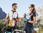 Zwei Radfahrer in Sportkleidung mit Trinkflaschen und Fahrrädern in den Bergen.