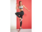 Frau in Sport-BH, Leggings und Sneakers in sportlicher Pose.