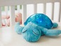 Ein blauer Plüsch-Schildkröten-Nachtlicht in einem Babybett
