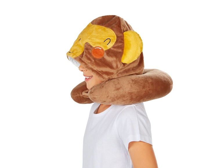 Ein Kind trägt ein Nackenkissen mit einem Affenkopf.