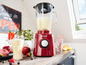 Ein roter Russell Hobbs Mixer mit einem Glas Smoothie daneben.